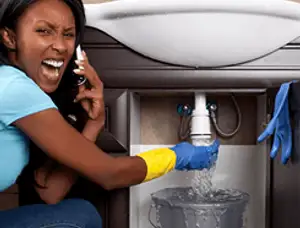 Emergency plumbing repair for a leaking sink drain under a bathroom vanity in Redding, CA