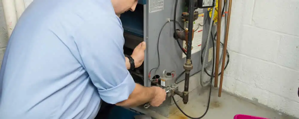 Furnace repair technician inspecting and servicing a home heating system in Redding, CA