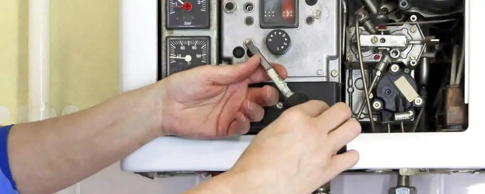 Heating repair technician adjusting boiler controls and components in Redding, CA