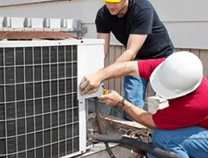 HVAC technicians repairing an outdoor AC unit on a rooftop in Redding, CA