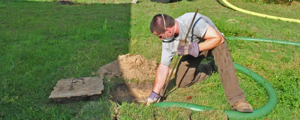 Septic pumping technician servicing a residential septic tank in Redding, CA